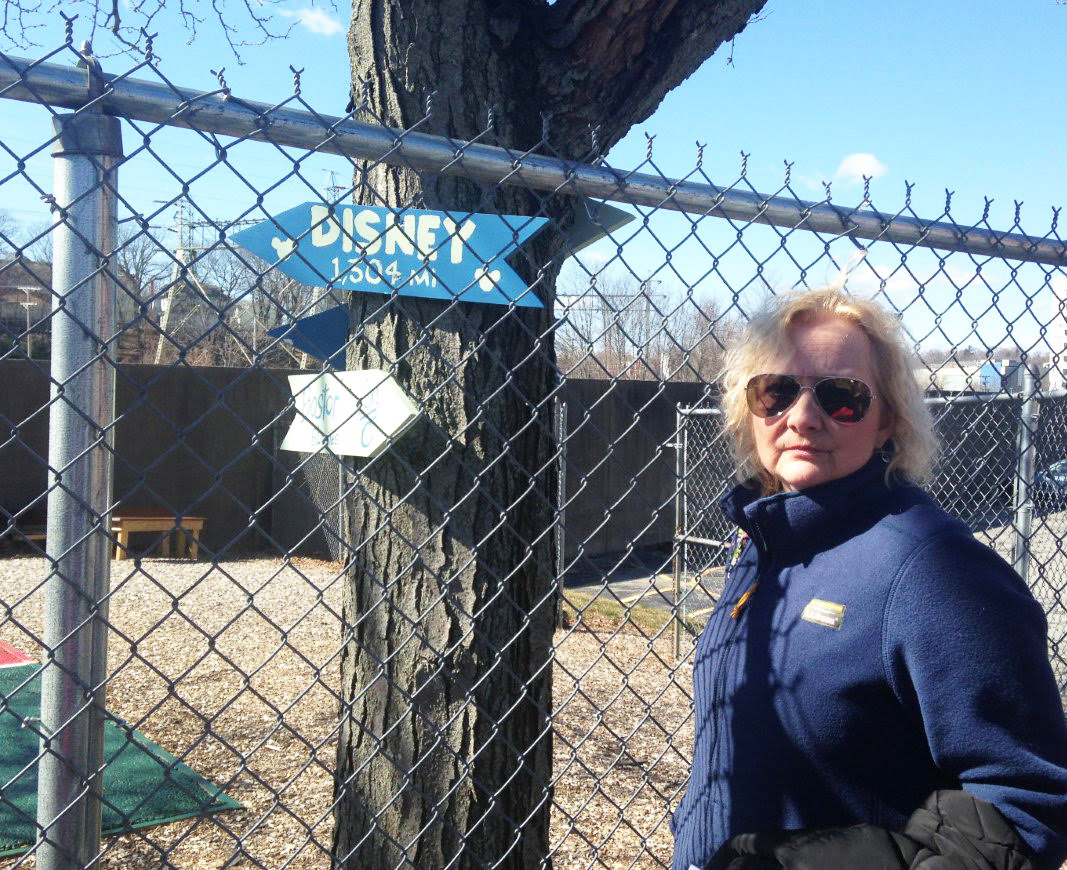 In a photo from 2020, Karen Rathbun of Community Care Alliance sands in front of a playground that had been constructed by volunteers from Blue Cross Blue Shield of RI. BHDDH plans to evict the agency from the state-owned building.